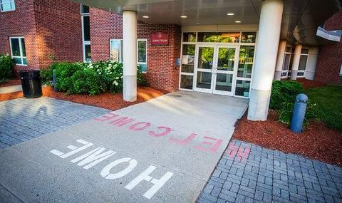 The words "Welcome Home" are painted in red and white on the walkway leading into Scott Hall